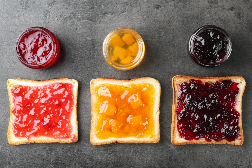 Delicious toasts with various sweet jams on grey background