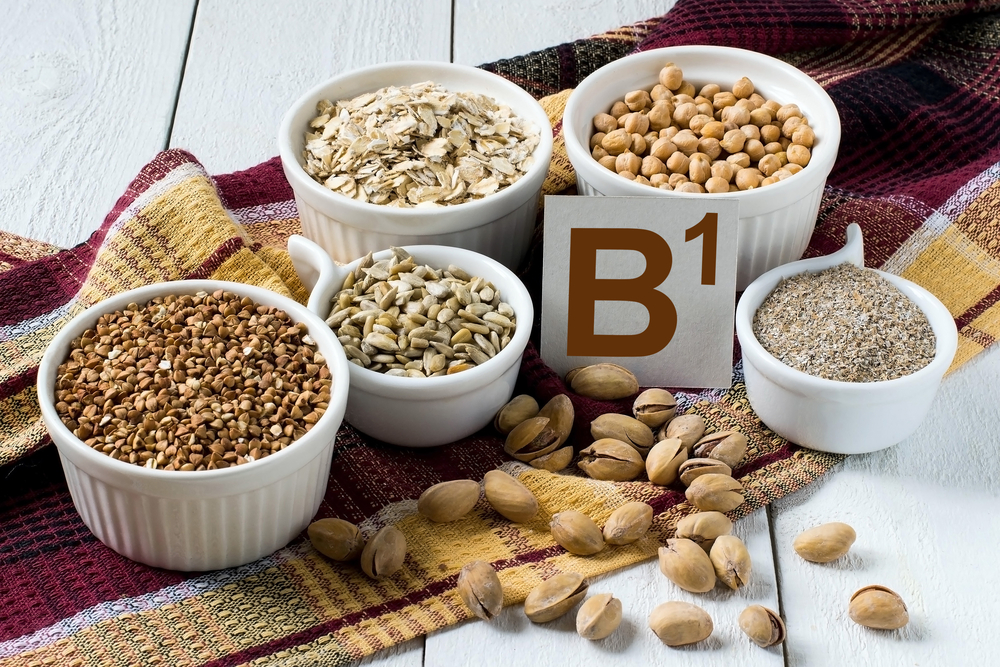 Foods rich in vitamin B1: buckwheat, oatmeal, bran, sunflower seeds, peas, pistachio nuts in a cup on a brown napkin