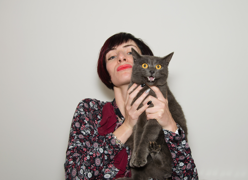 Studio portrait of beautiful girl with funny chartreux cat