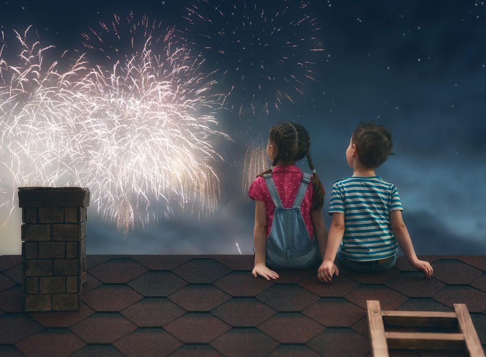 屋根の上で花火観賞をする子供たち