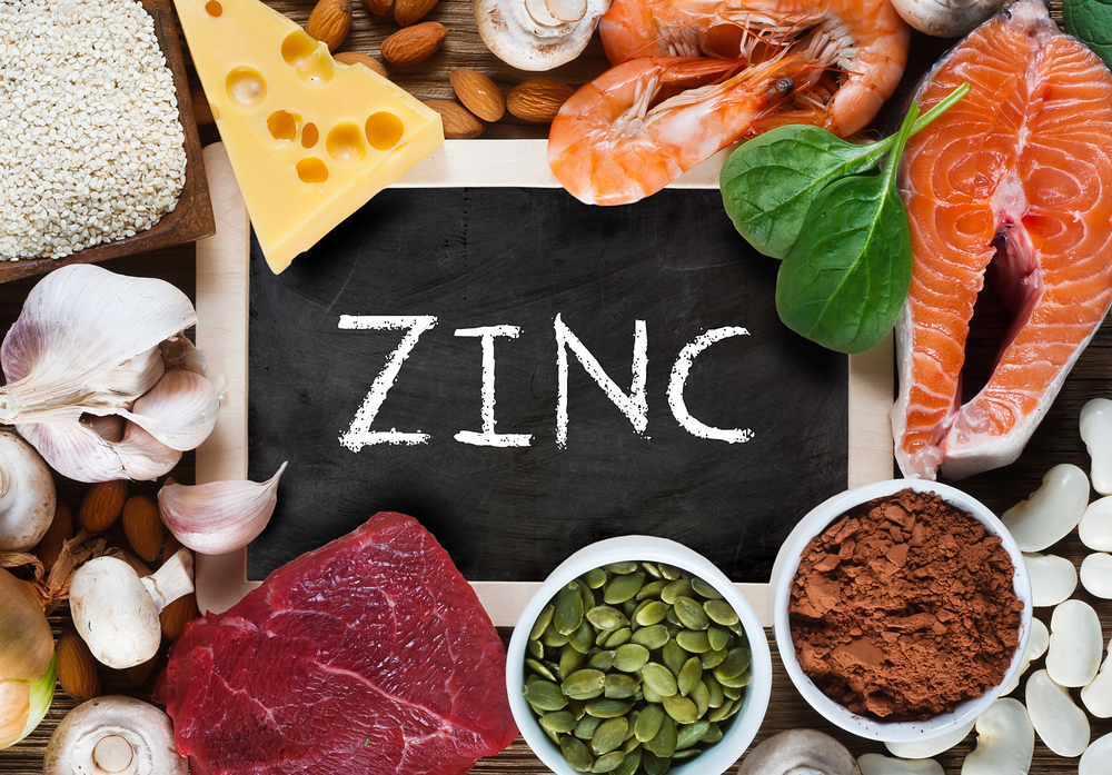 Foods High in Zinc as salmon, seafood-shrimps, beef, yellow cheese, spinach, mushrooms, cocoa, pumpkin seeds, garlic, sesame, bean and almonds. Top view