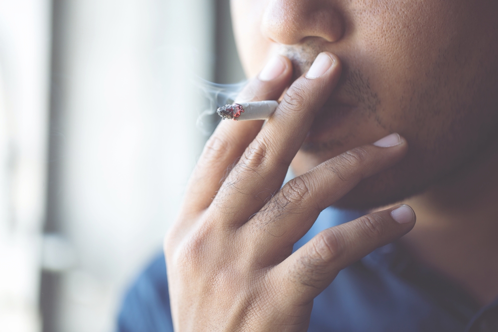 man smoking a cigarette. Cigarette smoke spread. 