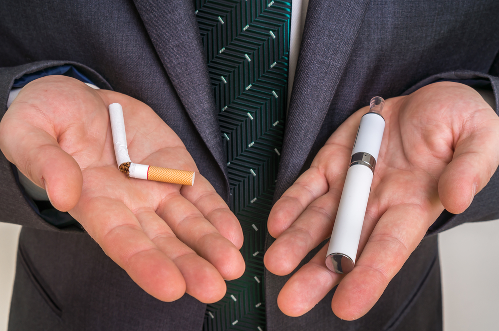 Businessman offers a choice between tobacco cigarette and electronic cigarette