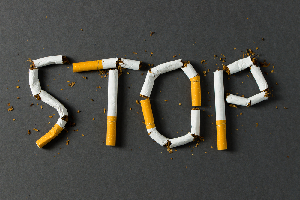 The word stop spelled using cigarettes on black background