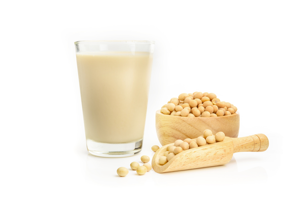 Soy milk with soybeans isolated on white background. 