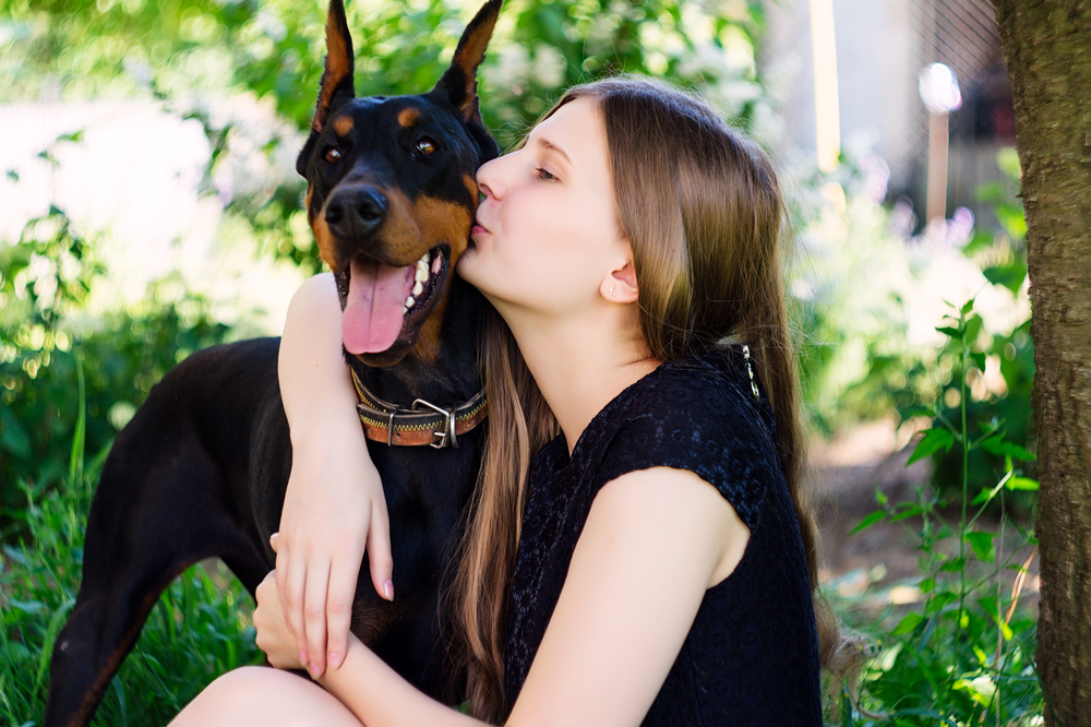 Young beautiful girl with Dog Doberman