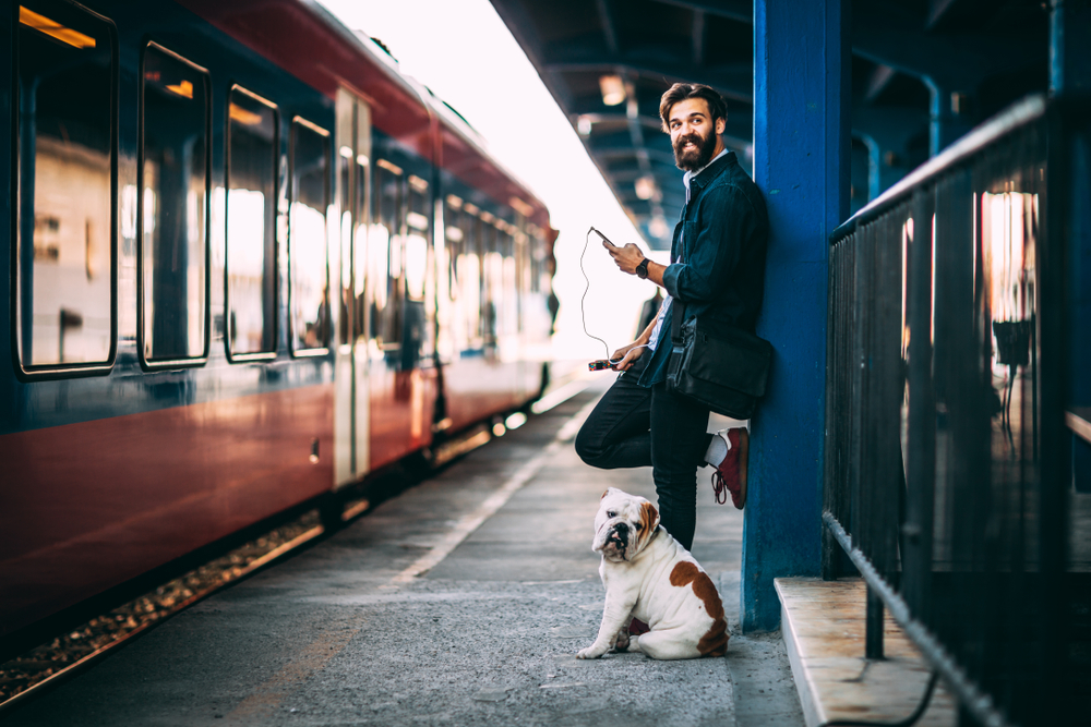 犬と電車を待つ男性